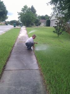 A dale City Sprinkler Repair Contractor adjusts a sprinkler head